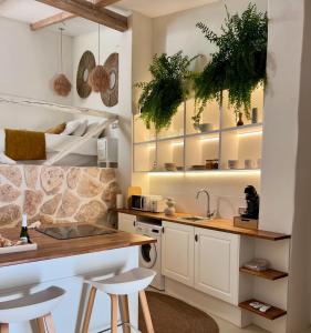 a kitchen with white cabinets and a counter and stools at Tu Casita Rural in Valdilecha