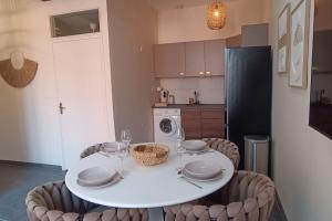 a kitchen with a white table and chairs and a kitchen with a refrigerator at La filature Balnéo in Tourcoing