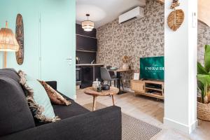a living room with a couch and a tv at Emeraude Duplex in Saint-Paul-Trois-Châteaux