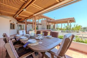 a wooden table and chairs on a patio at Platanias Memories Apartment in Platanias