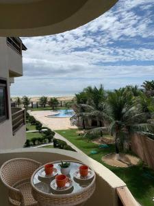 a table on a balcony with a view of a resort at Flat Marezzi - Pé na areia - Taíba CE in São Gonçalo do Amarante