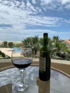 a glass of wine sitting next to a bottle of wine at Flat Marezzi - Pé na areia - Taíba CE in São Gonçalo do Amarante