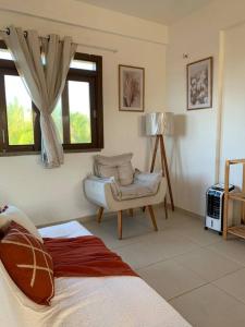 a living room with a bed and a chair at Flat Marezzi - Pé na areia - Taíba CE in São Gonçalo do Amarante +42 photos
