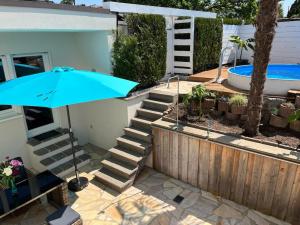 ein blauer Sonnenschirm neben einem Haus mit Swimmingpool in der Unterkunft City Chillout Heidelberg Appartement with Sauna & Pool in Heidelberg