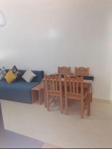 a living room with a blue couch and a table and chairs at Apartamento de lujo Martil in Martil