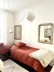 a bedroom with two beds and a mirror at Studio climatisé pour 1 ou 2 personnes au 109 avenue Mozart Paris 16 in Paris