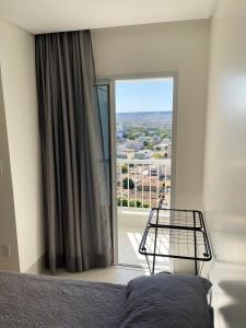 a bedroom with a bed and a large window at Ap 805 com suíte Edifício City House in Barreiras +26 photos