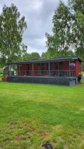 a red building with a green field in front of it at Pids randõ in Kolka