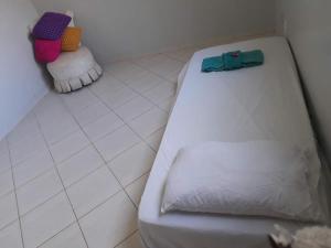 a white bed sitting on a tiled floor in a room at casa cachoeira in Brasilia