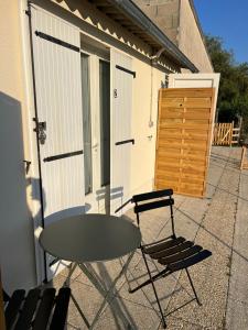 a table and two chairs on a patio at Chez Laurie et Xavier studio 1 in Mignaloux-Beauvoir