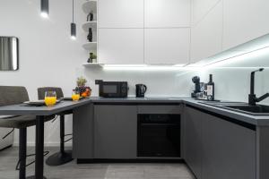 a kitchen with black and white cabinets and a table at Apartment Centar Trogir in Trogir