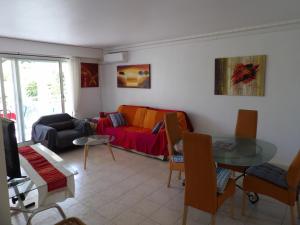 a living room with a couch and a table at 3P, Cannes, Domaine securise, Piscine, Tennis, Golf, 3 Etoiles in Cannes