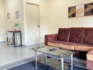 a living room with a couch and a table at Penthouse Desaru Beach 5G Wifi Netflix Pool View in Bandar Penawar