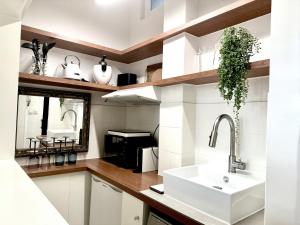 a white kitchen with a sink and a mirror at Studio climatisé pour 1 ou 2 personnes au 109 avenue Mozart Paris 16 in Paris +12 photos