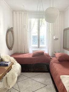 a bedroom with two beds and a window at Studio climatisé pour 1 ou 2 personnes au 109 avenue Mozart Paris 16 in Paris