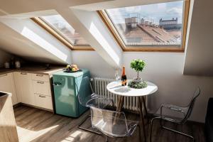 a small kitchen with a table and a green refrigerator at Queen Flat in Old Town with Castle view in Bratislava