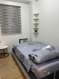a bedroom with a bed with a comforter on it at JK's Haven in Naga