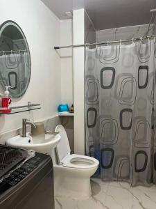 a bathroom with a toilet and a shower curtain at JK's Haven in Naga +36 photos