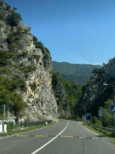 an empty road next to a rocky mountain at Khimshura in Khimshi