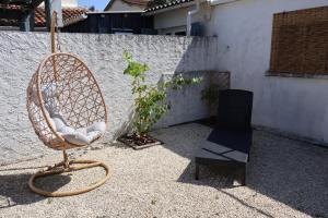 a rattan chair and a black chair on a patio at Studio Avec jardin privé in Bergerac