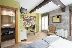 a bedroom with a bed and a bathroom with a sink at CimaVilla Rooms in Gijón