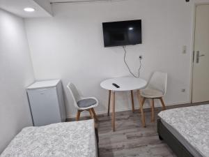 a room with two beds and a table and two chairs at Tulpe in Günzburg