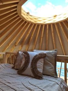 a bed in a wooden room with a round window at Jurta w Dolinie Sanu in Krzemienna