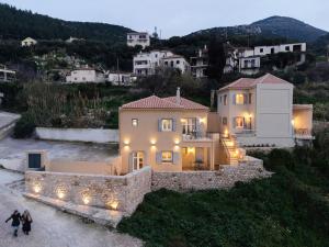 a large house with lights on top of it at Sirocco Maisonette - Kyparissia Old Town Home Collection in Kyparissia