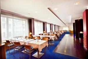 eine Reihe von Tischen und Stühlen in einem Restaurant in der Unterkunft Hotel Strudlhof Vienna in Wien