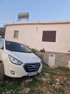 a white car parked in front of a house at Guest House Vajzë S,Kasaj in Vlorë
