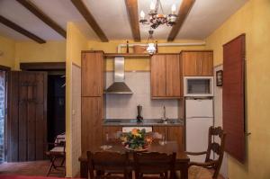 a kitchen with a table and a refrigerator at Apartamentos Rurales Alvado in Tamajón