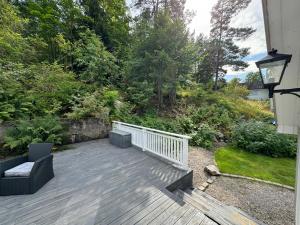 a wooden deck with two chairs and a fence at Cosy cabin in Risør in Risør
