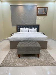 a bedroom with a large bed with a ottoman at MASA Hotel in Khamis Mushayt