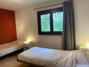 a bedroom with two beds and a window at Hébergement in Jalhay