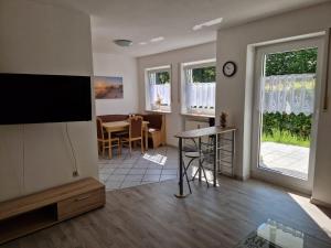 a living room with a television and a dining room at Ferienwohnung Unterneukirchen mit Garten-Terrasse in Unterneukirchen