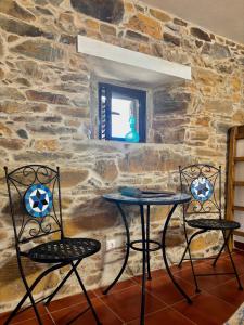 two chairs and a table in front of a stone wall at Casa Da Oliveira in Pedrógão Grande +31 photos
