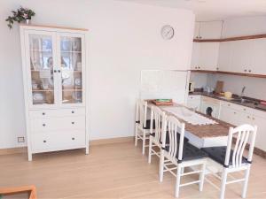 une cuisine avec des armoires blanches et une table et des chaises dans l'établissement Ático Agarimos do Mar, à Corcubión 18 autres photos