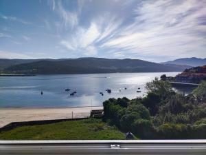 - une vue sur un lac avec des bateaux dans l'eau dans l'établissement Ático Agarimos do Mar, à Corcubión