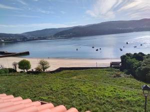 a view of a beach with boats in the water at Ático Agarimos do Mar in Corcubión