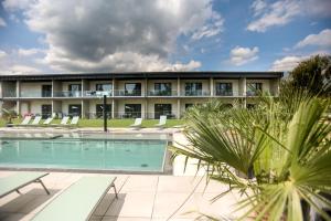 a hotel with a swimming pool and lounge chairs at Beach Arena Csopak in Csopak