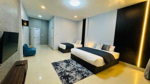 a hotel room with two beds and a bathroom at Vela House Hatyai in Hat Yai