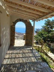 a patio with an archway with the ocean in the background at Tinian View Bee Home Maisonette in Arnados