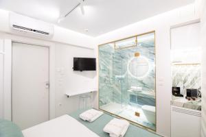 a white bathroom with a shower and a bed at Luxury - Le petit Bati in Volos