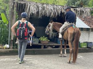a man riding a horse next to a woman at Finca Ometepe in Balgue