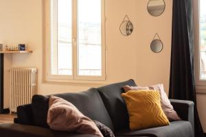 a living room with a couch and a window at Grand Appartement Lumineux au Centre d'Aurillac in Aurillac