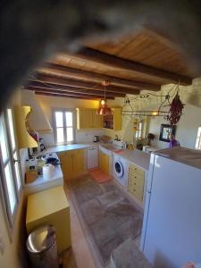 a large kitchen with yellow cabinets and a sink at Tinian View Bee Home Maisonette in Arnados