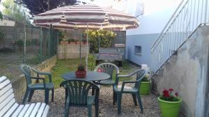 a patio with a table and chairs and an umbrella at Gite le figuier de l'ill in Sélestat