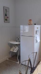 a kitchen with a white refrigerator and a stool at Gite le figuier de l'ill in Sélestat