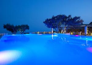 una gran piscina por la noche con luces azules en Kakkos Bay Hotel and Bungalows, en Ierápetra