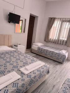 a room with two beds and a flat screen tv at Kalipso motel in Çeşme